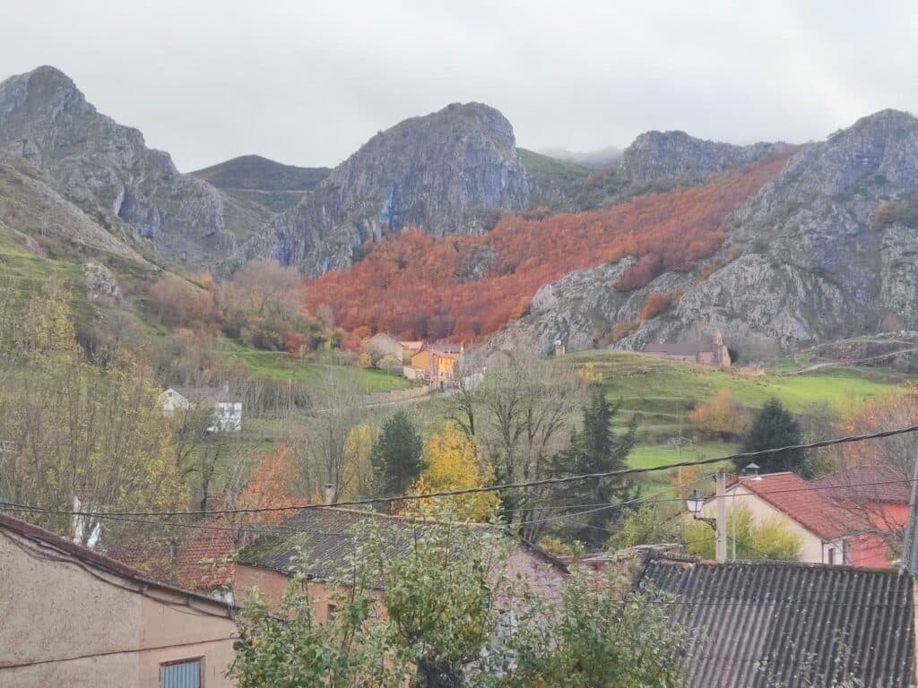 El hayedo de Bodón teñido de rojo en otoño sobre los crestones